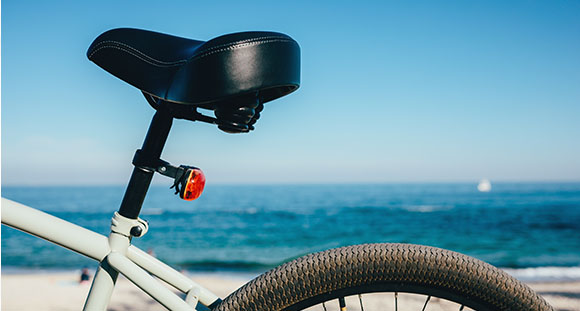 a closeup of a bicycle seat with the ocean in the background