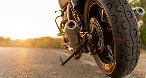 a closeup of a motorcycles tires driving along a road