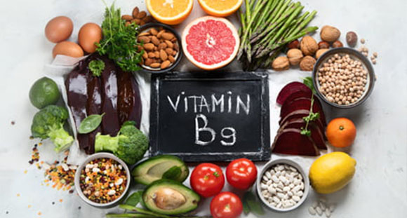 a blackboard with Vitamin B9 written on it, surrounded with food sources of the vitamin