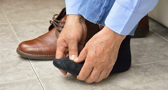 a man holding his painful foot from diabetes
