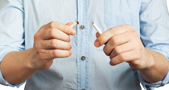 a man snapping a cigarette in half