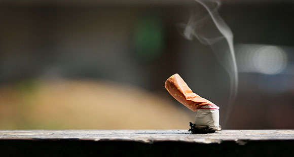 a crushed cigarette on top of a stone wall