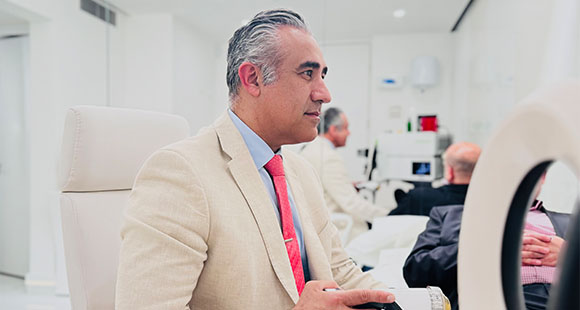 Mr. Almashan talking with clients in a consultation in a white office room