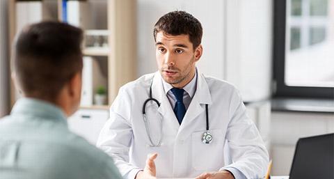 a male doctor talking with a male patient about penile implants